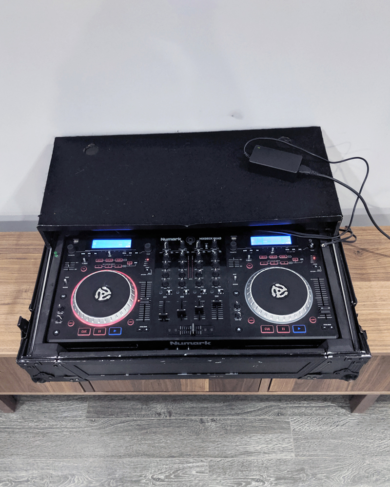 Numark DJ deck on wood table.