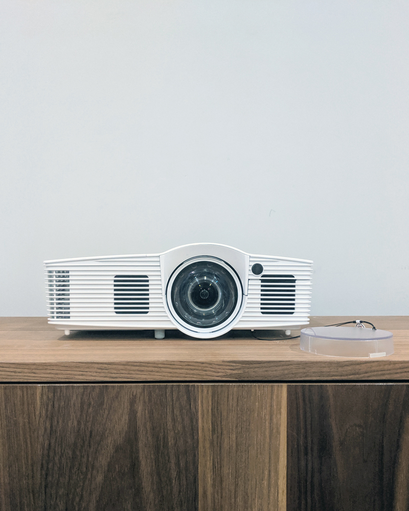 White projector on wood table.
